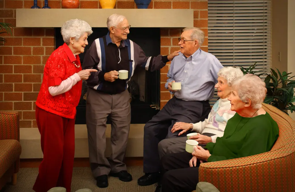 Older adults and family sharing senior living holiday activities around a festive dinner table
