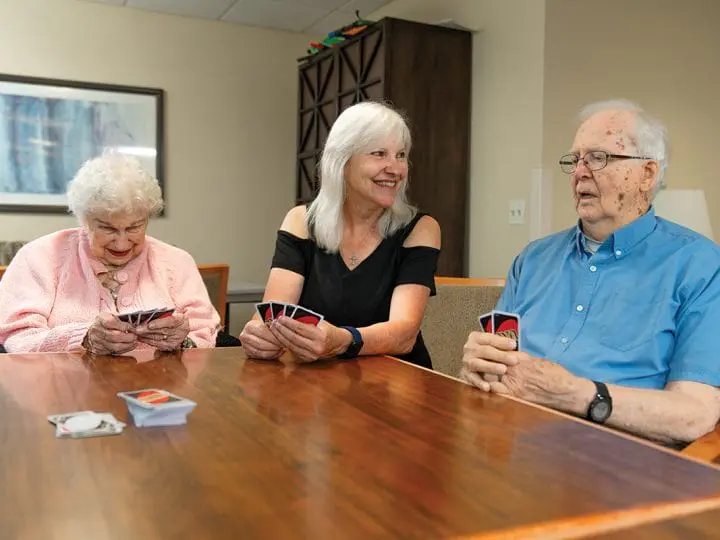A woman plays Uno with residents that she volunteers with at the senior living community.