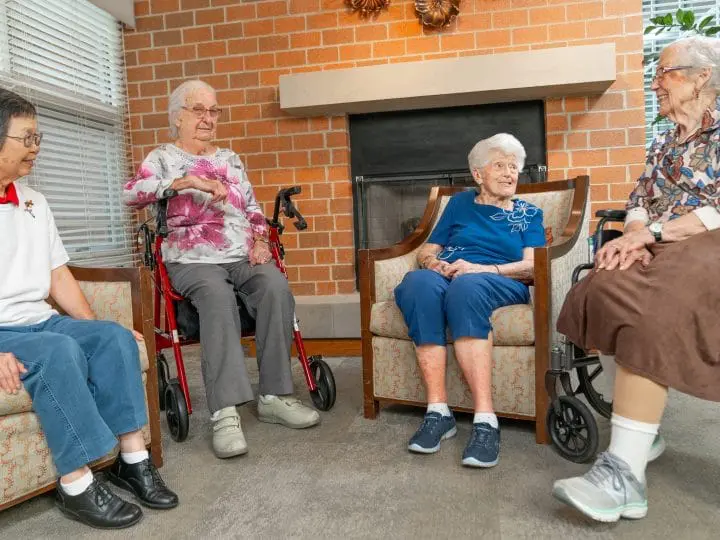 A group of seniors seated together and discussing their day, showcasing the tight-knit community.