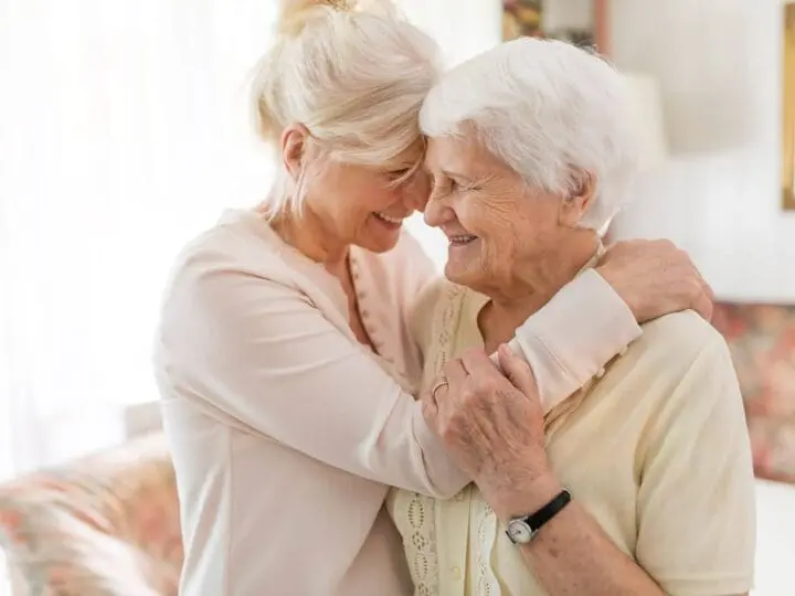 A woman embraces her elderly mother, talking to her about moving to Assisted Living
