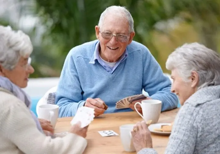 Three elderly friends discuss dementia-friendly community options.