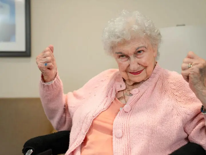 A woman clenching her fists looking accomplished as she achieves a goal.