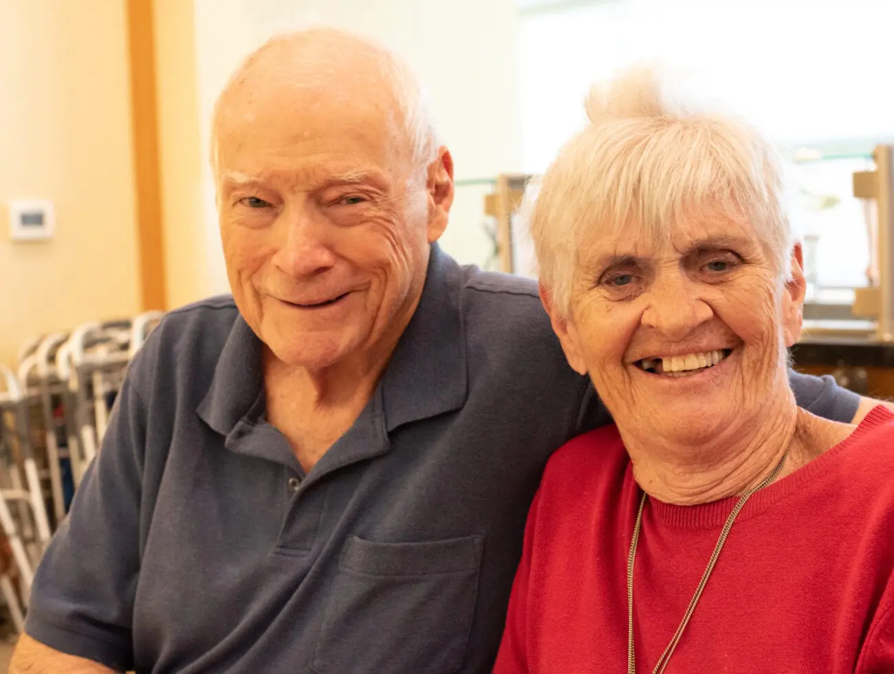 Two seniors with dementia pictured together smiling, showcasing the importance of friendship.