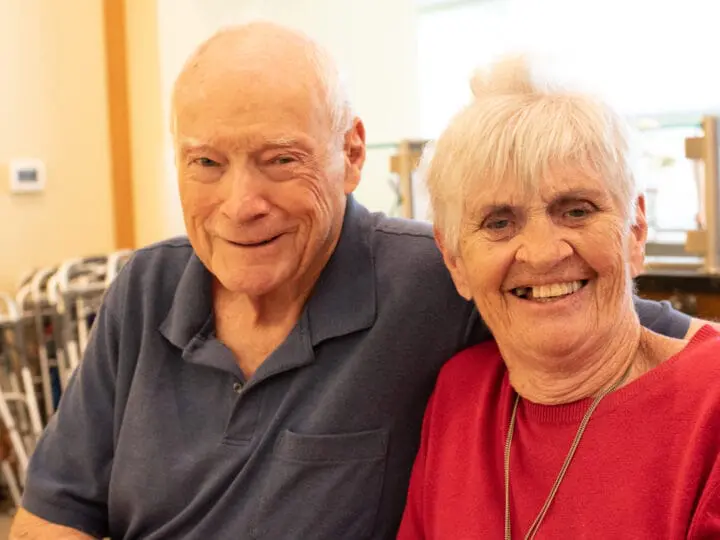 Two seniors with dementia pictured together smiling, showcasing the importance of friendship.