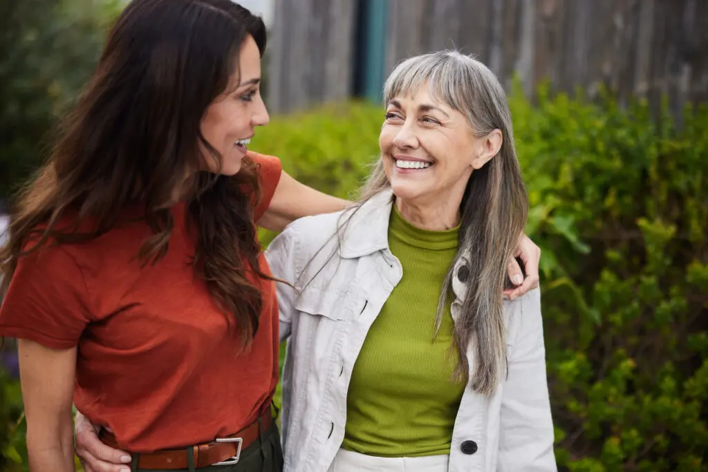 Senior woman and younger woman smiling and walking
