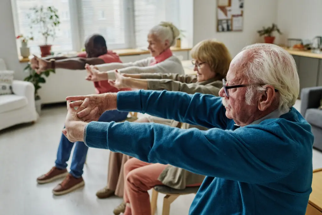 A group of older adults in a seated strength class practicing mobility exercises for seniors at Central Baptist Village.
