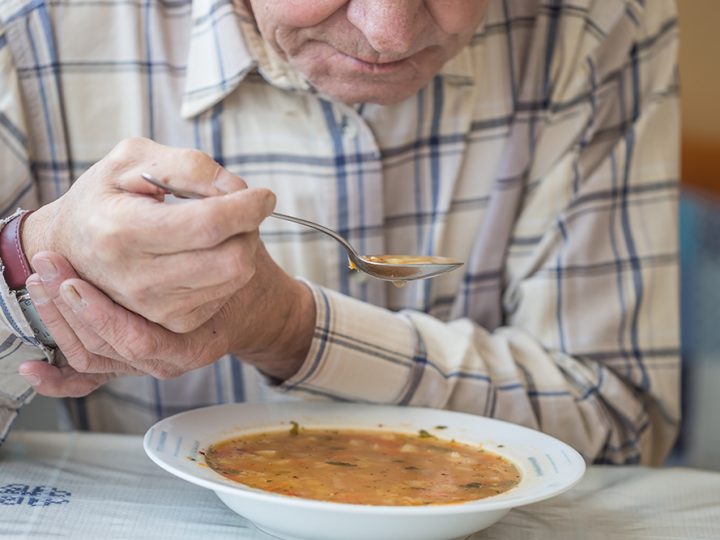 Man with Parkinson's and movement disorder eating soup