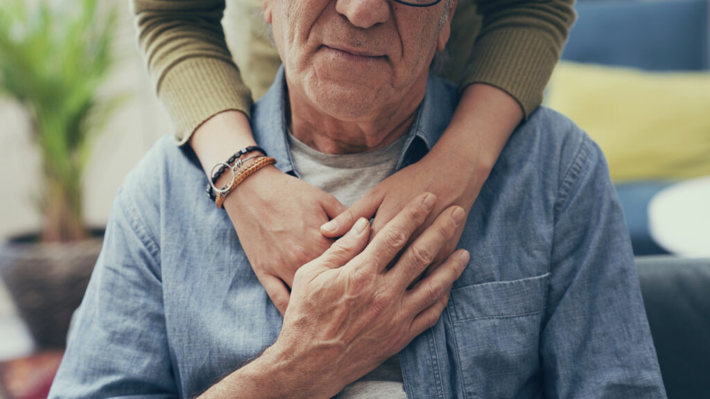 Comforting hands on senior man's shoulders