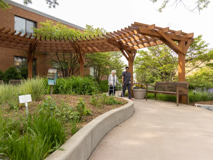 Resident walking with her caregiver outdoors