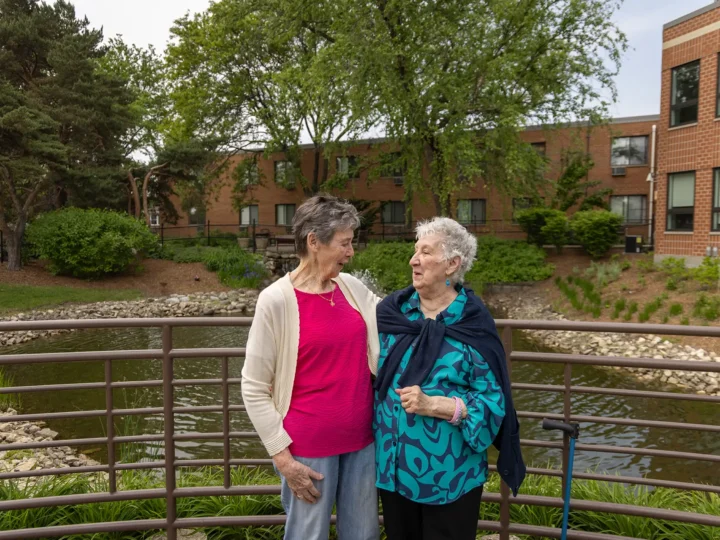 Two residents chatting by a fountain outdoors