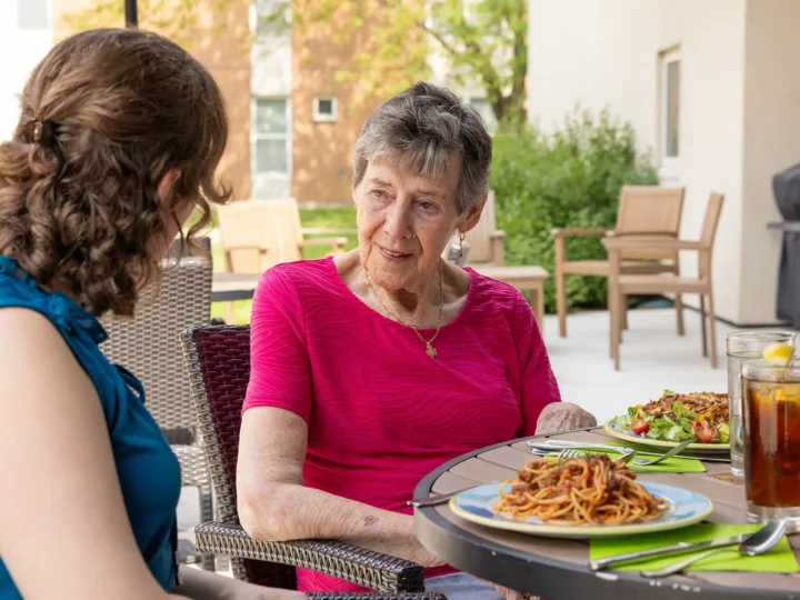Resident dining outdoors with her visiting family