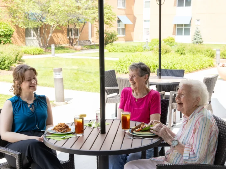 Resident dining outdoors with her visiting family