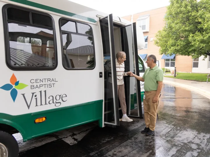 Resident being helped off the van after Scheduled Transportation