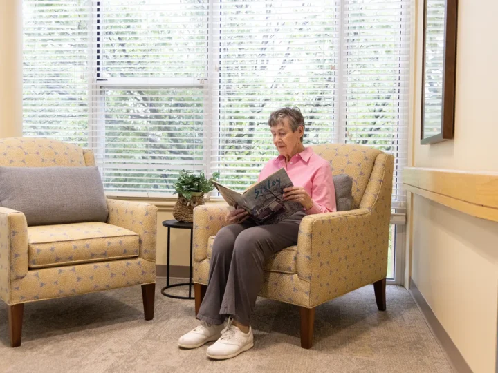 Resident reading a book in a common sitting area