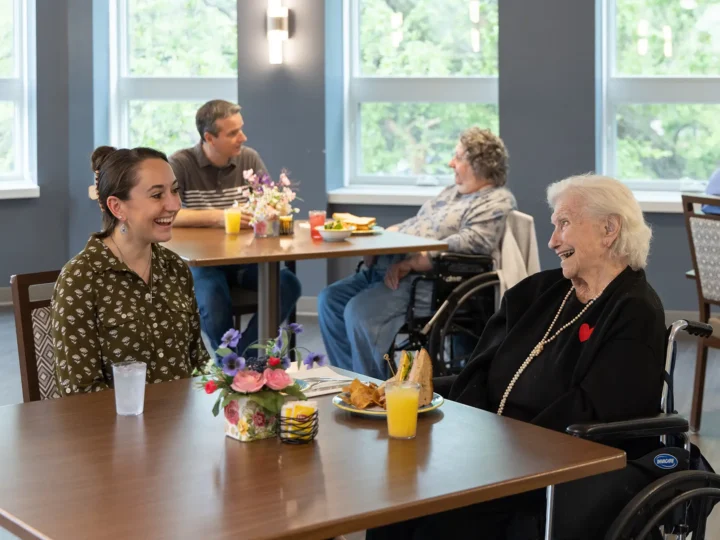 Resident enjoying a meal with her caregiver