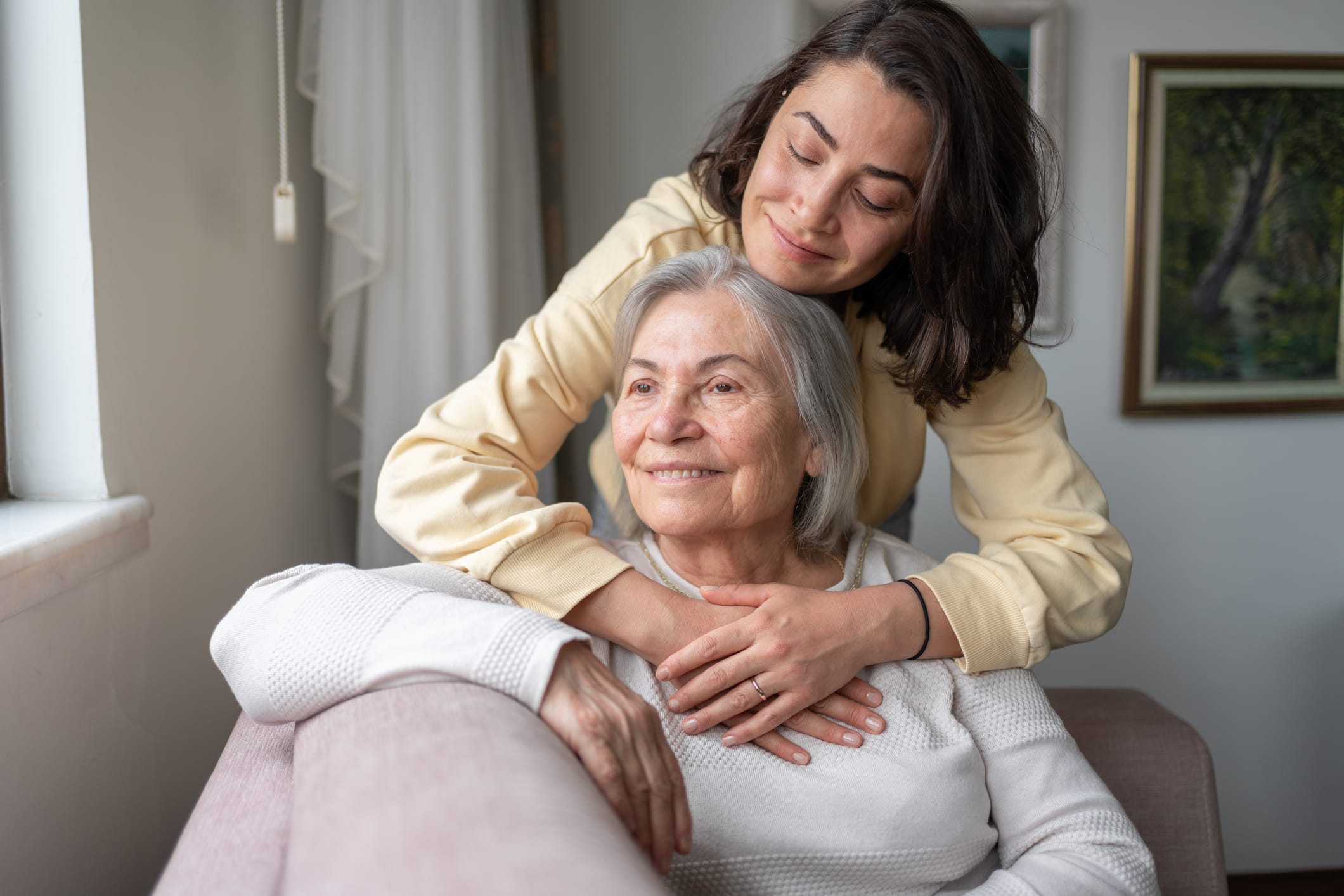 Adult daughter hugging senior mother