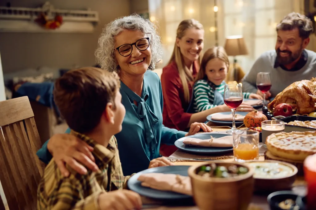Older adults and family sharing senior living holiday activities around a festive dinner table