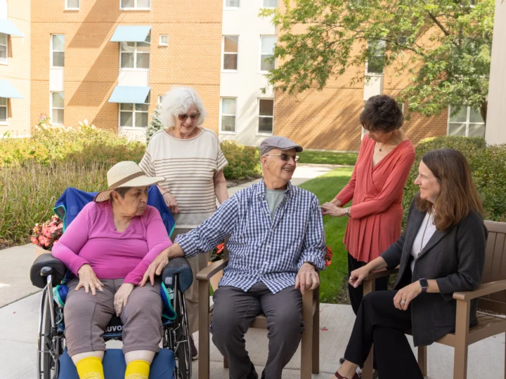 A groups of seniors smiling and talking, showing the different levels of care in Assisted Living, available at Central Baptist Village in Illinois.
