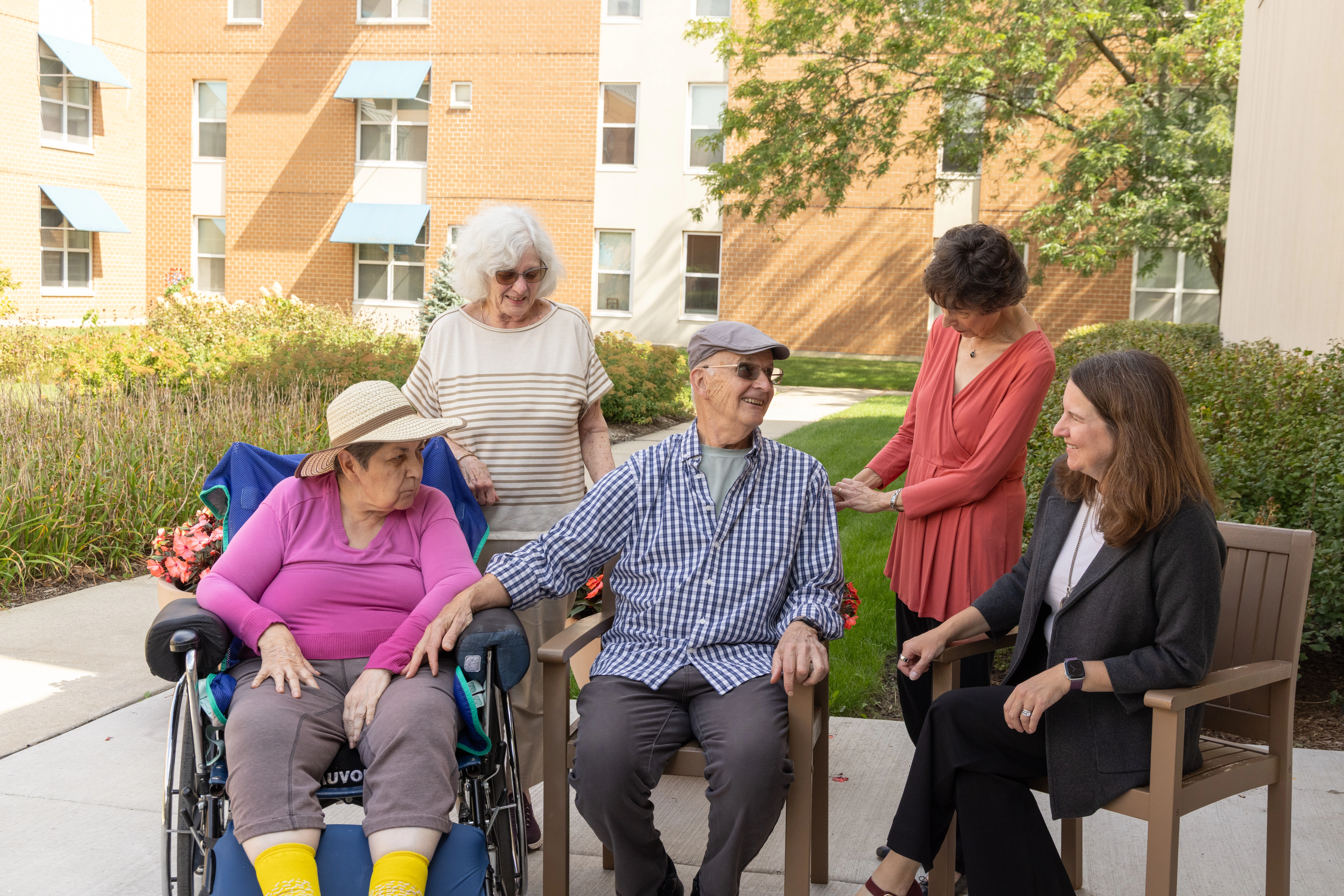 A groups of seniors smiling and talking, showing the different levels of care in Assisted Living, available at Central Baptist Village in Illinois.