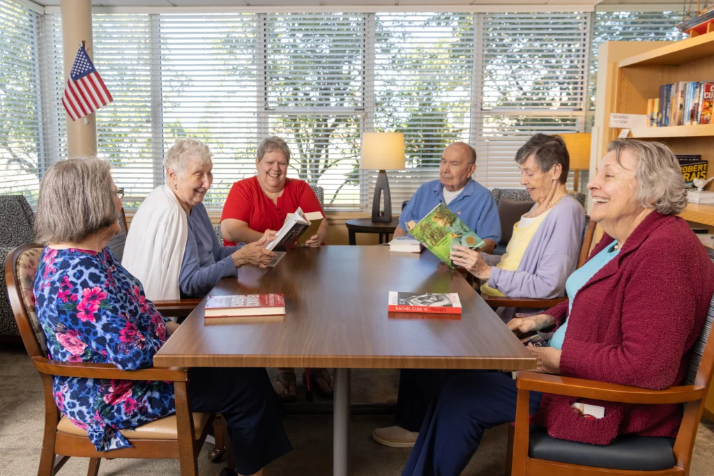 A group of seniors reading books and discussing the levels of care in Assisted Living at Central Baptist Village in Norridge, IL.